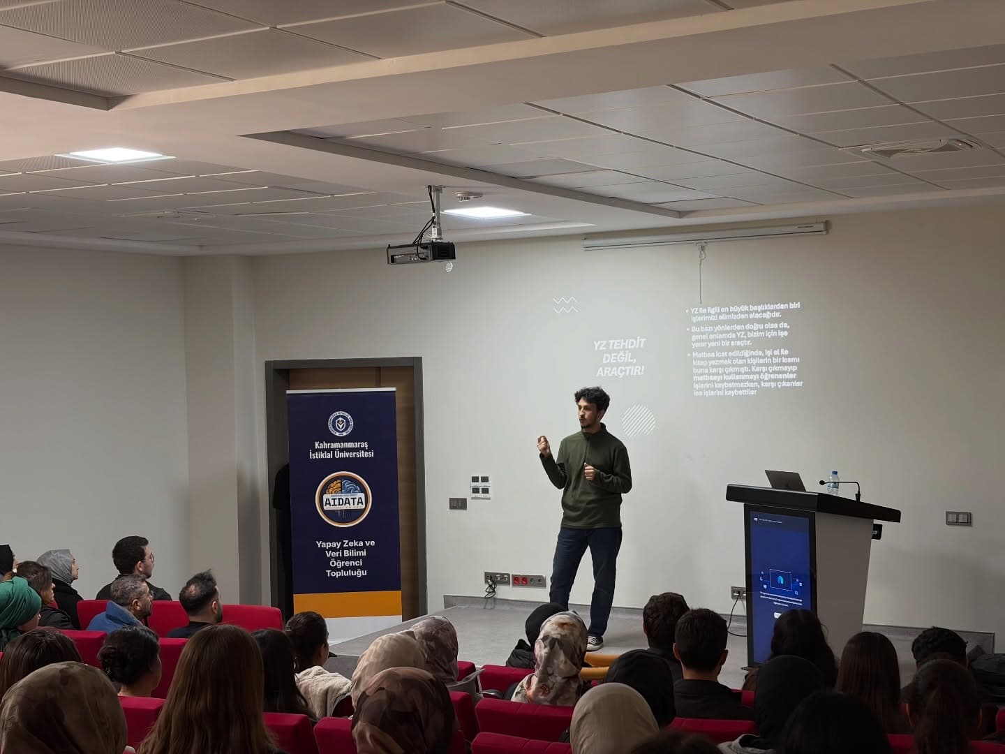 Sağlık Bilimleri Fakültesi'nde AIDATA pankartı önünde seminer konuşması